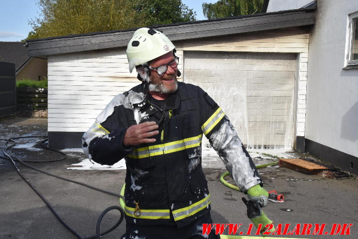 Ild i Carport. Nørre Bygade i Grejs. 02/08-2024. Kl. 17:34.