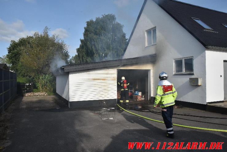 Ild i Carport. Nørre Bygade i Grejs. 02/08-2024. Kl. 17:34.