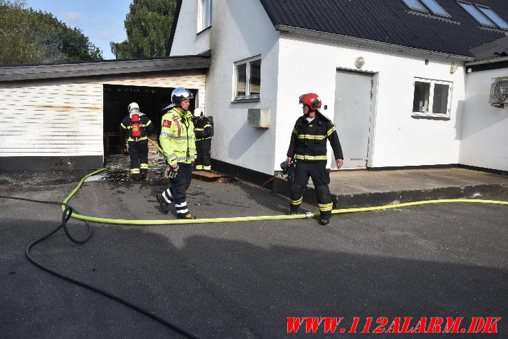 Ild i Carport. Nørre Bygade i Grejs. 02/08-2024. Kl. 17:34.